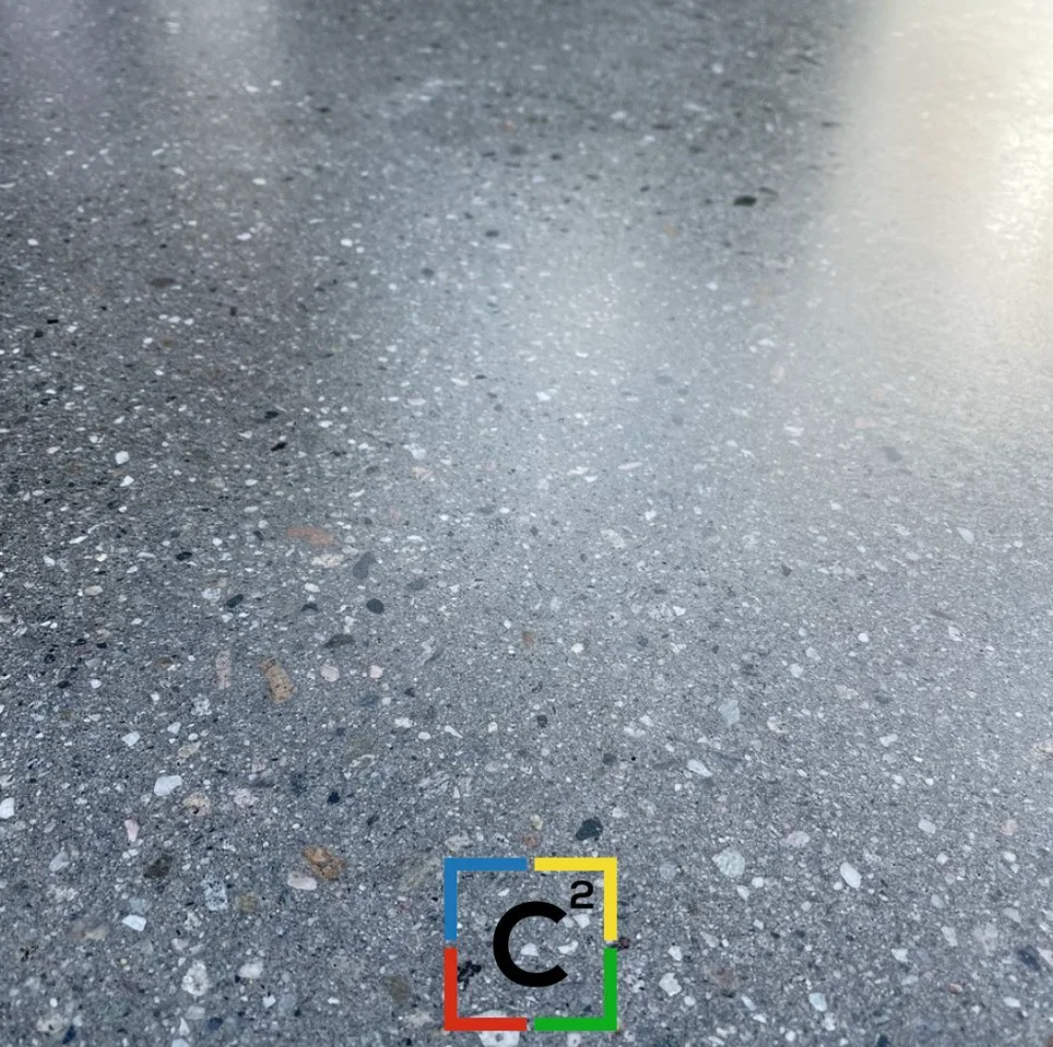 Piso de hormigón pulido con agregados visibles y brillo espejo